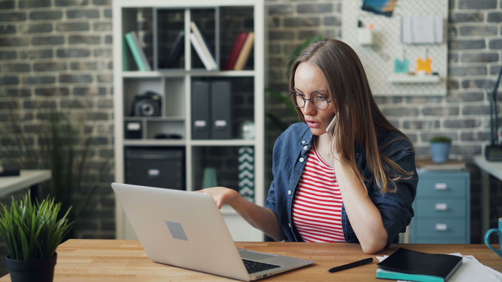 a woman sitting at a table using a laptop computer trying to understand why her homeowners insurance policy did not renew